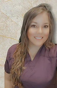 Dental hygienist Tammy in burgundy scrubs smiling against textured marble backdrop.